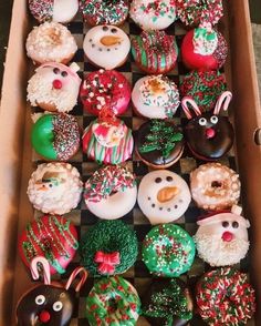 a box filled with lots of different types of doughnuts on top of a checkered table