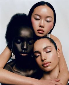 three women with black skin and white make up on their faces are hugging each other