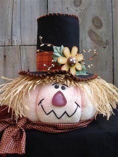 an image of a pumpkin with a scarecrow hat and flowers on it's head