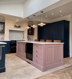 a large kitchen with an island in the middle and blue cabinets on both sides, along with marble flooring