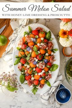 a white plate topped with salad next to other dishes and utensils on a table