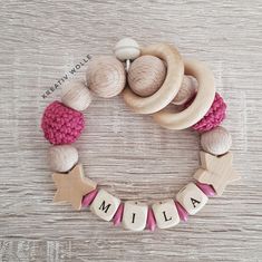 the name mia spelled with wooden letters on a white table next to yarn balls and crocheted beads