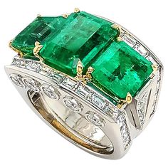 A remarkable green of emerald is the summit of this platinum ring adorned with diamonds. Three emeralds are displayed in emerald cuts, emphasizing brilliant hues and depth. 18k yellow gold prongs secure the gemstones. Platinum is the wide band, featuring a channel setting of baguette diamonds across the top and five bezel-set brilliant cut diamonds on each side of the bridge. Side stones of five ascending diamonds provide additional shine. The total weight is 10.36 carats of emeralds and 3.26 ca Luxury Multi-stone Emerald Ring With Diamonds, Luxury Diamond-cut Emerald Ring, Luxury Exquisite Emerald Ring, Luxury Green Diamond Ring, Exquisite Style, Luxury Multi-stone Emerald Ring In Fine Jewelry Style, Expensive Diamond, Trio Ring, Channel Setting, Baguette Diamonds