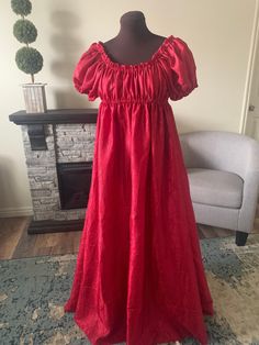 This delicate gown is the perfect summer dress for any renaissance or regency era ensemble! The ultra-full gown features an empire waistline, hitting right below the bust. The fabric is a light-weight ruby red taffeta, and will add that elegant touch to your existing wardrobe. Over 5 yards of fabric go into this dress. The neckline is elasticized and can be pulled low off the shoulders and the empire waistline is also elastic. The short sleeves measure 4 inches from underarm to elasticized hem a Jane Austen Pride And Prejudice, Delicate Gown, Full Gown, Medieval Gown, Old Fashion Dresses, Regency Era, Taffeta Dress, Empire Waistline, Under Dress