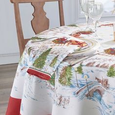 a dining room table with a santa clause print on the tablecloth and red chairs