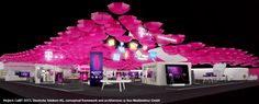 an exhibition stand with pink balloons on the ceiling