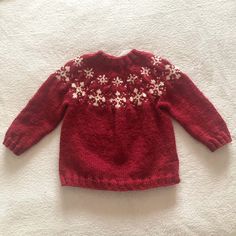 a red sweater with white snowflakes on it