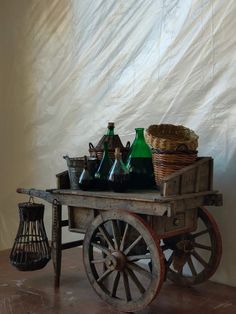 an old wooden cart with bottles and baskets on it