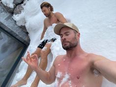 two men are sitting in the snow and one man is holding his hand out to him