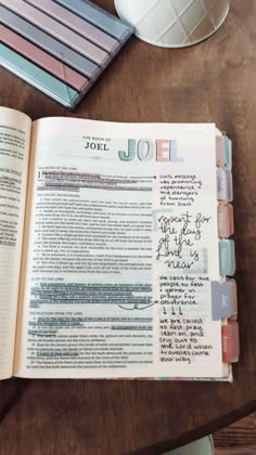 an open bible sitting on top of a wooden table