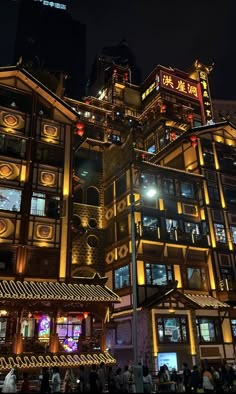 a large building with lots of windows and lights on it's sides at night