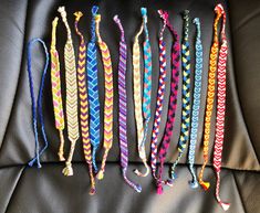 several different colored bracelets are lined up on a couch