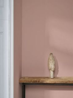 a white bird sitting on top of a wooden shelf