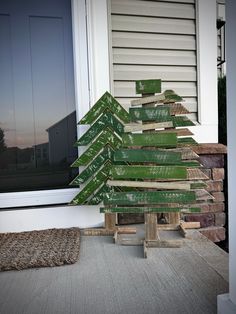 a wooden christmas tree sitting on top of a porch