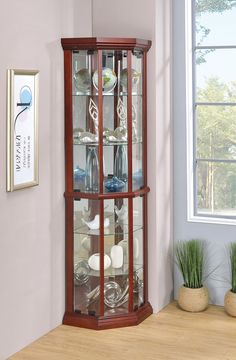 a corner display case with glass doors and wood trimmings on the top shelf