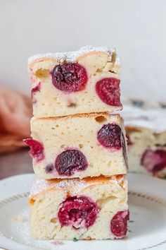 three pieces of cake on a plate with powdered sugar and raspberry topping