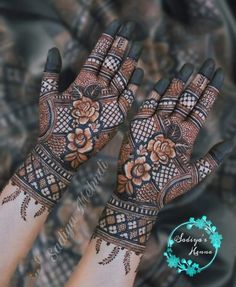 two hands with henna tattoos on them