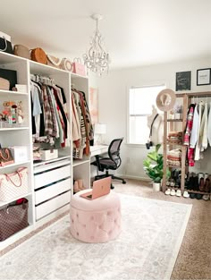 an organized closet with clothes, shoes and handbags on shelve shelves in front of a chandelier