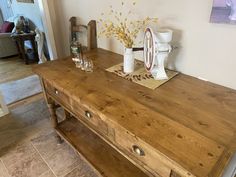 a wooden table with two vases on top of it next to a door way