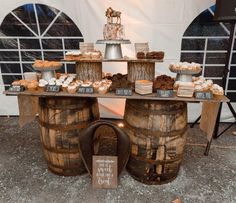 a table topped with wooden barrels filled with pastries