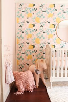 a baby's room decorated in pink, yellow and green with lemons on the wall