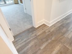 an empty room with white walls and wood flooring