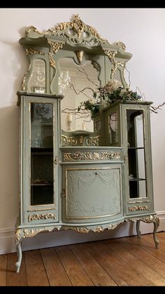 an old fashioned china cabinet with glass doors