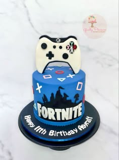 a birthday cake with a video game controller on top and the words fortnite printed on it