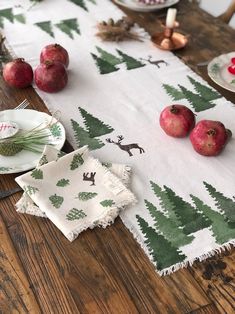 the table is set with apples and napkins on it, along with other dishes