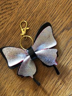 a keychain shaped like a butterfly sitting on top of a wooden table