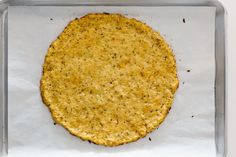 an uncooked tortilla sitting on top of a baking sheet in a pan