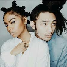 a young man and woman are posing for a photo with their hair in buns