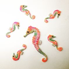 seahorses made out of beads on a white surface