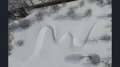 an aerial view of snow covered ground with trees