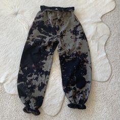 a pair of black and white pants laying on top of a rug