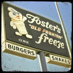 an old fashion ice cream sign on the side of a building in front of a blue sky