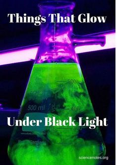 a flask filled with green liquid sitting on top of a table next to a neon light