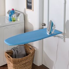 an ironing board is hanging on the wall next to a laundry basket