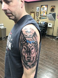 a man with a wolf tattoo on his arm