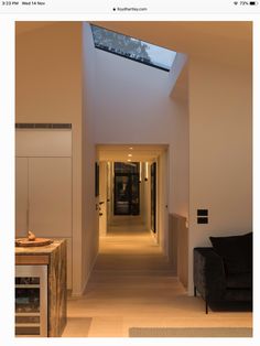 an empty hallway leading to a living room and dining room with skylights on the ceiling