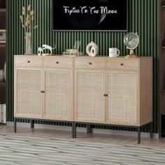 a living room with green striped walls and a large television mounted above the sideboard