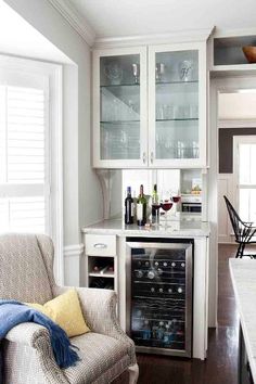 a kitchen with white cabinets and glass doors