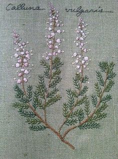 some pink flowers and green leaves on a white cloth with words written in black ink