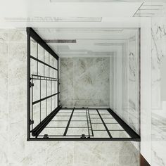 an empty room with white marble walls and black metal bars on the floor, in front of a window