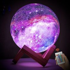 a purple and blue night light on top of a wooden stand