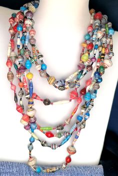 a multi strand beaded necklace is displayed on a mannequin