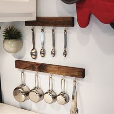 a kitchen with utensils and spoons hanging from the hooks on the wall