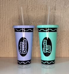 two cups with straws in them sitting on a table