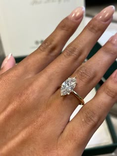 a woman's hand with a diamond ring on it