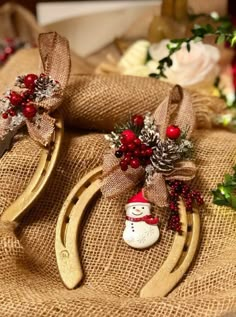 two christmas decorations are sitting on some burlocks with snowmen and pine cones